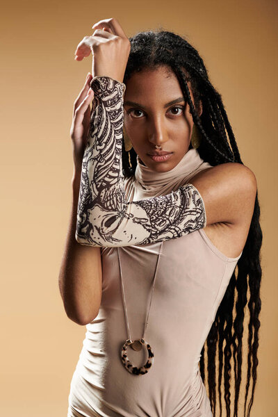 Стильная молодая женщина демонстрирует свою моду со сложными украшениями для рук и шикарным костюмом.