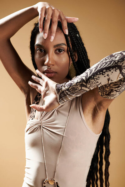 Уверенная в себе молодая женщина демонстрирует свой стильный наряд, творчески позируя в теплой обстановке.