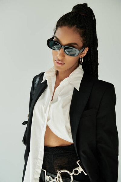 Модная молодая женщина демонстрирует свой неповторимый стиль с уверенностью и блеском в освещении помещений.