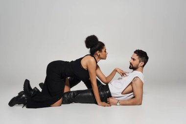 Bir çift birbirine sıkıca sarılıyor, minimalist bir ortamda sevgi ve çekicilik sergiliyor..