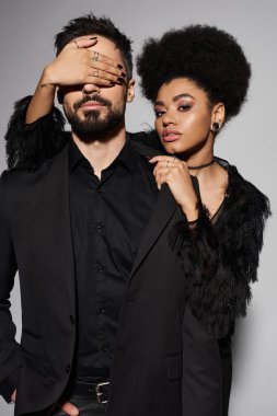 Kendine güvenen bir çift tutkuyla kucaklaşır. Sevgisini ve tarzını koordine siyah kıyafetlerle gösterir..