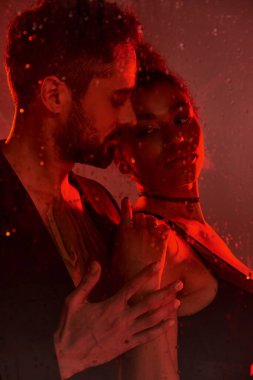 Bir çift arasında tutkulu bir kucaklaşma, parlayan bir atmosferin ortasındaki derin bağlantılarını vurgular..