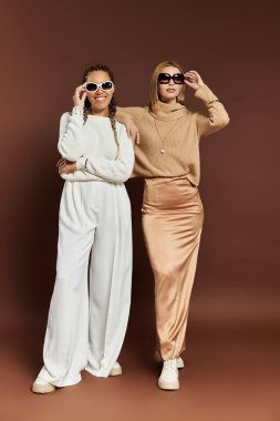 İki şık kadın birlikte canlı bir günün tadını çıkarırken sonbahar modasını sergiliyorlar..