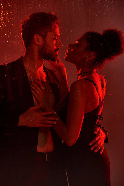 Пара разделяет интимный момент, окруженный теплым светом и нежным дождем.