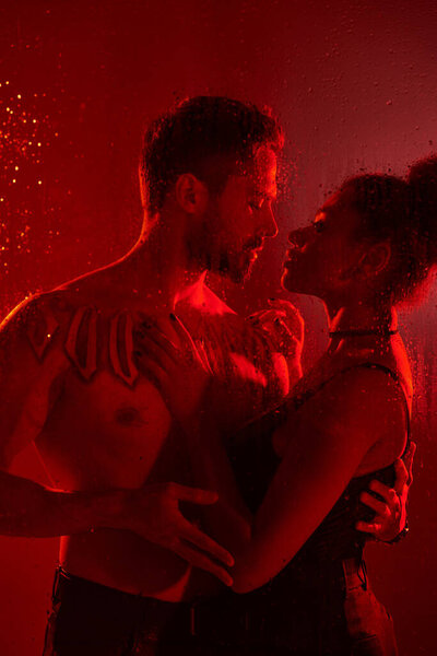 Пара разделяет интимный момент, очарованный присутствием друг друга в яркой обстановке.