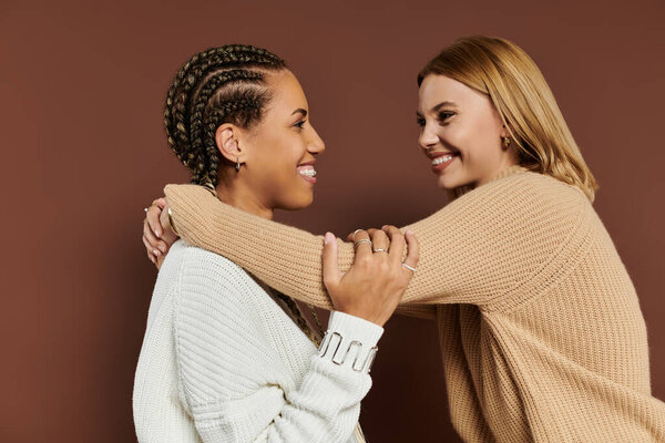 A beautiful lesbian couple shares joyful moments, wrapped in warm autumn clothing during fall.