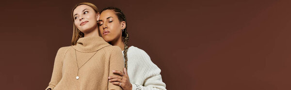 A young couple enjoys an intimate moment, embracing each other in their autumn attire.