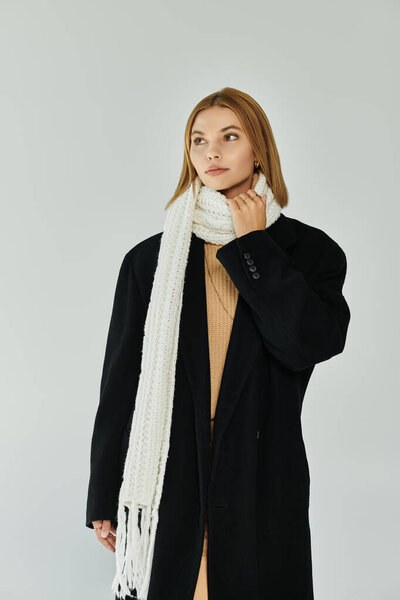 Обращаясь женщина в элегантной теплой одежде позирует активно.