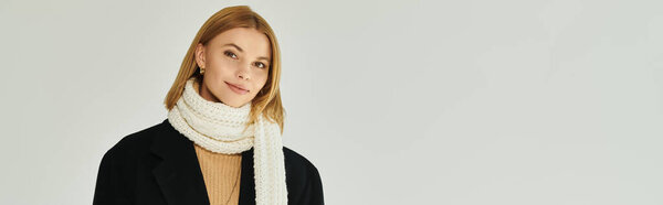 Fashionable woman in elegant warm attire posing actively.