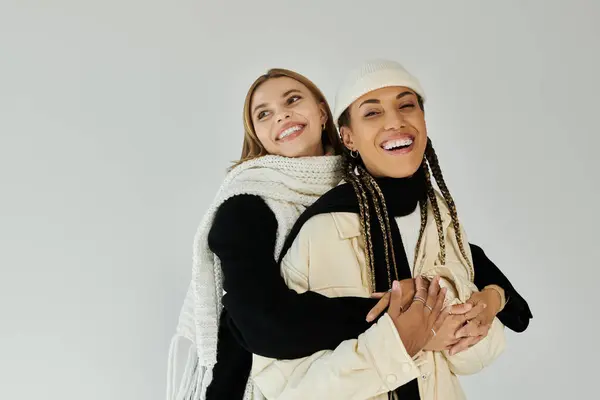 stock image A young couple dressed in autumn layers shares a warm embrace, showcasing love and joy.