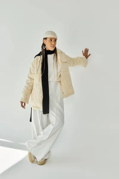 stock image Appealing young woman in stylish warm attire posing on white backdrop.