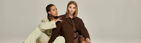 stock image Two stylish young women embrace in fashionable autumn outfits, sharing an intimate moment indoors.