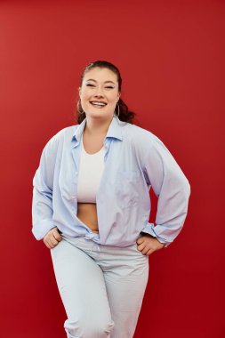 Bir güzellik güven ve neşe saçar, cesur makyajlar sergiler ve gururla ayakta duran şık bir takım elbise.