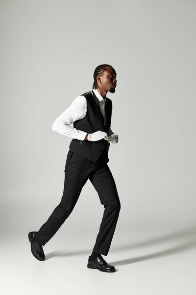 A young African American man confidently strides in a tailored suit with elegance and energy.