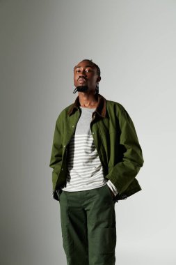 Genç bir Afrikalı Amerikalı, kendine has moda anlayışını yeşil ceketi ve pantolonuyla sergiliyor..