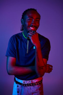 Genç bir Afrikalı Amerikalı, canlı neon ışıkları altında poz verirken eşsiz tarzını sergiliyor..