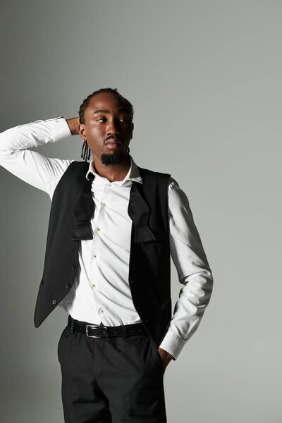 Молодой афроамериканец излучает уверенность в гладком костюме и стильном жилете, элегантно захваченном.