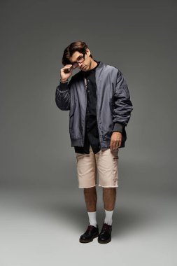 Genç bir adam, kendine güveni tam bir sonbahar elbisesi içinde duruyor. Moda anlayışını ve eşsiz tarzını vurguluyor..