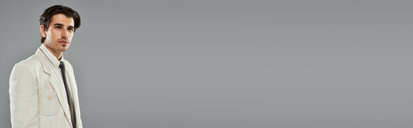 Молодой, красивый мужчина демонстрирует свою модную вечернюю одежду, излучая элегантность в студии.