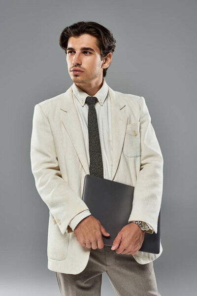 Молодой человек в элегантной формальной одежде стоит наготове, передавая харизму и уверенность в обстановке студии.