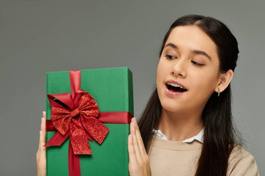Kadın, güzel paketlenmiş bir hediyeyi tutarken zevk sergiliyor..