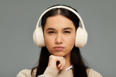Şık giyinmiş, derin derin düşünüyor, kulaklıklar düşüncelerini müzik ritmiyle kaplıyor..
