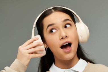 Tarz sahibi genç bir kadın kulaklıkla müzik dinlerken sevinç ifade eder..