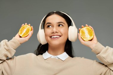 Mutlu genç bir kadın, elinde limon parçalarıyla neşe içinde müzik dinler..