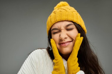 Duygusal genç bir kadın neşe saçar, şık kış aksesuarları giyer..