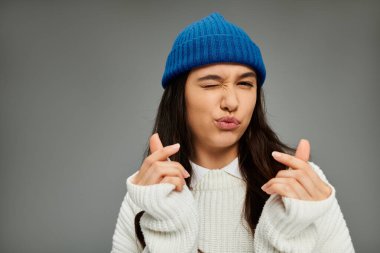Modaya uygun bir kadın, gençlik enerjisi saçarak, elleriyle göz kırparak el kol hareketi yapar..