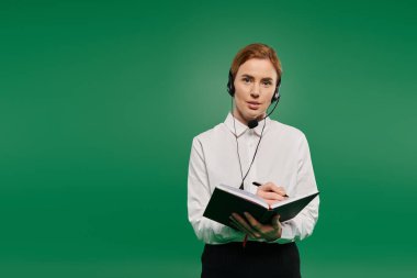 Beyaz gömlek giyen kendine güvenen bir kadın çağrı merkezinde konuşurken not alır..