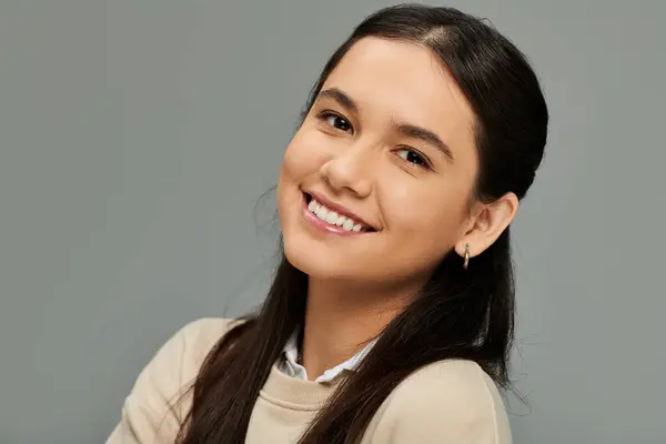 stock image A young woman exhibits genuine happiness, showcasing her stylish attire with an inviting smile.