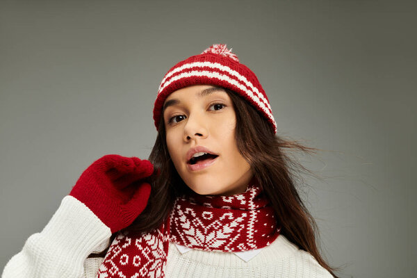 A young woman radiates emotion while showcasing her cozy winter outfit and accessories.