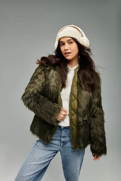 stock image A young woman displays a stylish winter outfit, combining fashion with emotion.