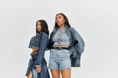 İki genç kadın, şık kot ceketleri ve eşsiz bluzlarıyla çağdaş moda sergiliyor..