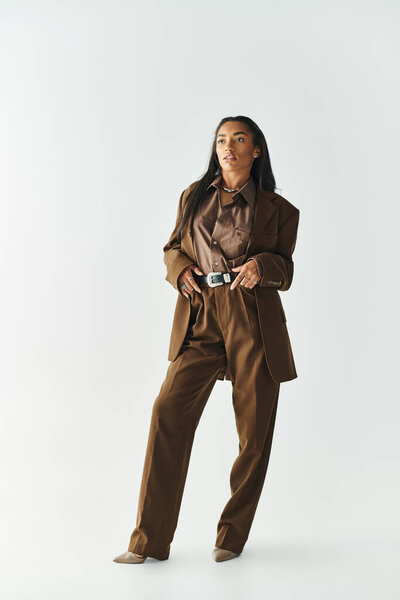 Молодая женщина демонстрирует свой модный стиль в современном наряде, излучая уверенность.