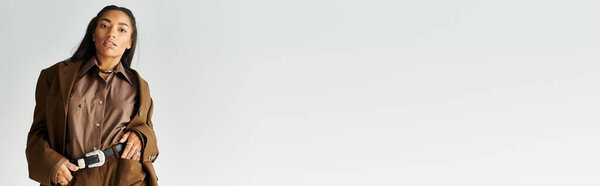 Модная молодая женщина демонстрирует свой стильный наряд с чутьем, источая уверенность и изящество.