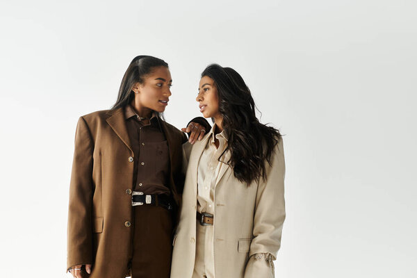 Две стильные девушки разговаривают оживленно, излучая уверенность и моду.