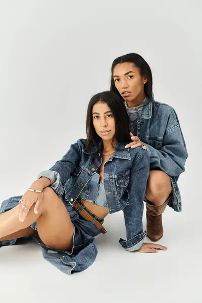 stock image Two young women in trendy denim outfits exude confidence and style while posing together.