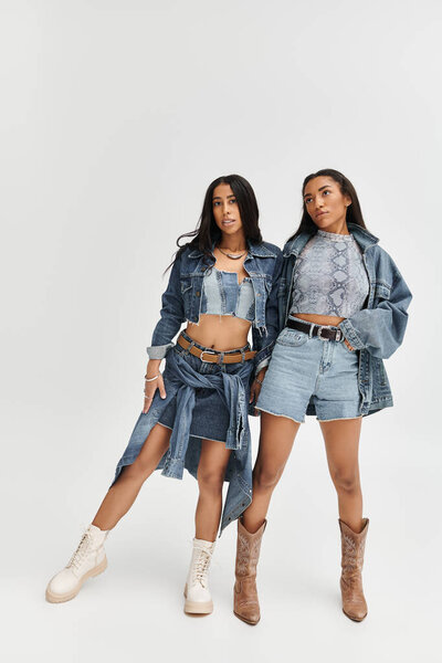 Модная молодая женщина выражает себя в модных джинсовых нарядах, ярко позируя.