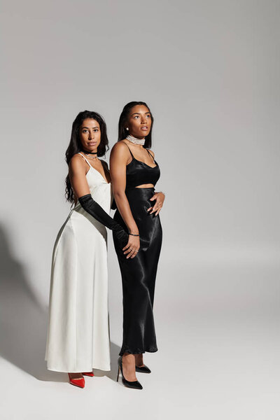 Два модно одетых друга позируют игриво, демонстрируя свои уникальные стили и красивые улыбки.