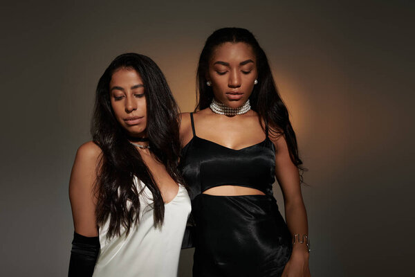 Две молодые женщины в потрясающих нарядах излучают гламур и изысканность в захватывающий момент.