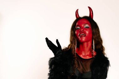 Bu Cadılar Bayramı 'nda, çarpıcı bir kadın enerjik şeytan kostümünü, kendine güvenen ve yetenekli bir şekilde sergiliyor..