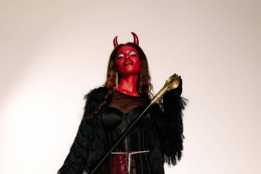 Çarpıcı figür, şeytandan esinlendiği kostümüne hayran kalıyor. Çekici detaylar sergiliyor..