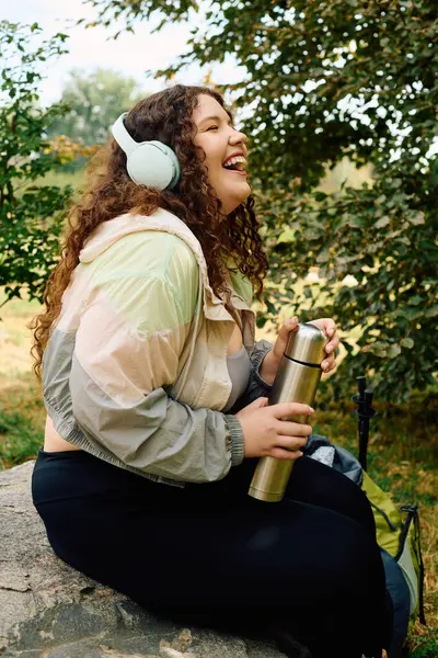 stock image A beautiful plus size woman sits in a lush forest, smiling and soaking up the natural beauty.