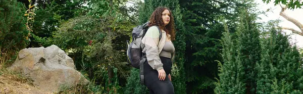 stock image A confident plus size woman enjoys a peaceful moment surrounded by vibrant greenery in nature.