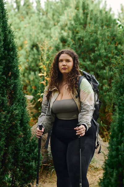 Излучая уверенность, плюс размер женщина наслаждается своим путешествием по безмятежной пустыне.