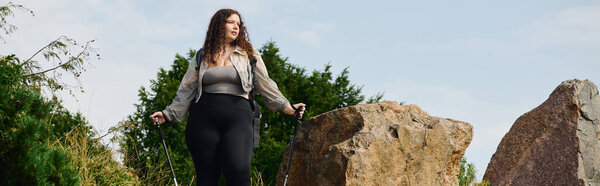 Уверенная в себе женщина plus size наслаждается природной красотой серенового поля во время прогулки.