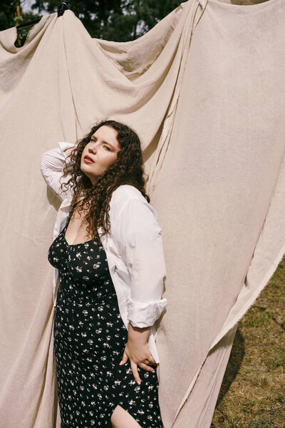 A stunning plus size woman stands confidently in a vibrant field, radiating natures beauty.