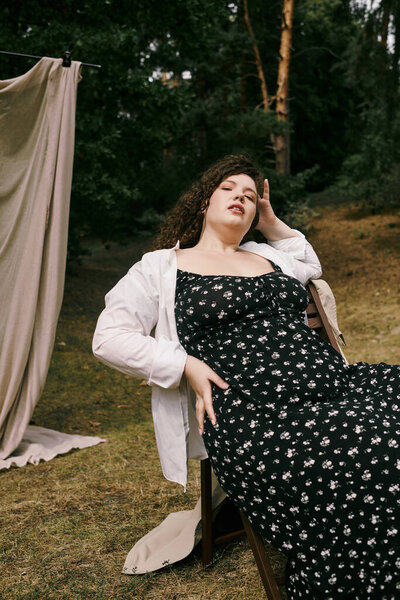 A confident plus size woman relaxes in a sunny field, embracing the beauty of nature around her.